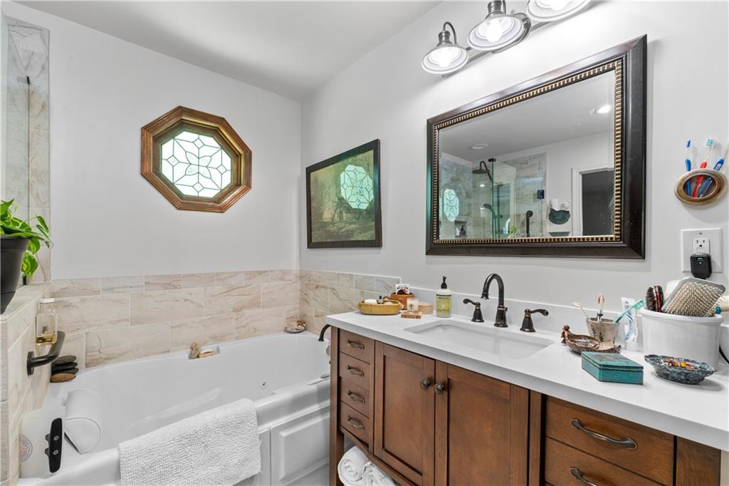 511 Oakdale Road Canton, GA 30114 - Photo 21 of 50 a bathroom with a sink a large mirror and a bathtub