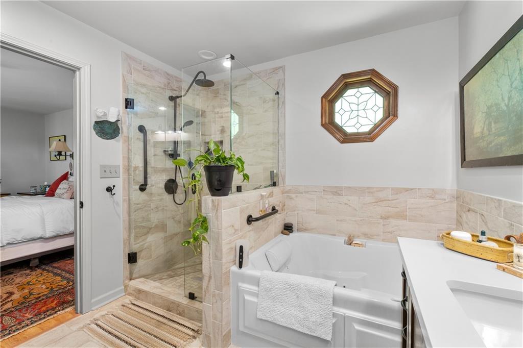 511 Oakdale Road Canton, GA 30114 - Photo 22 of 50 a bathroom with a bathtub a mirror and a shower