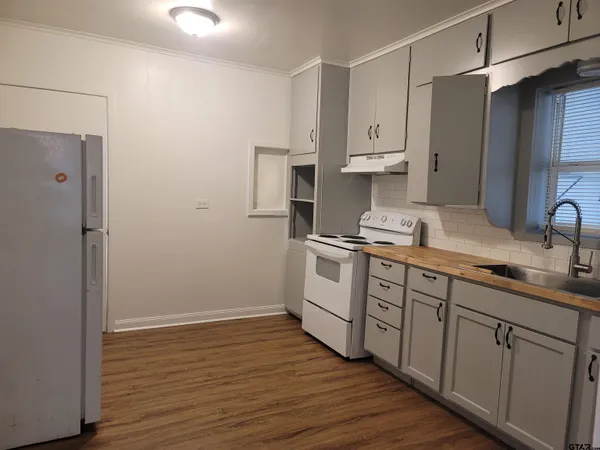 a kitchen with white cabinets and white appliances