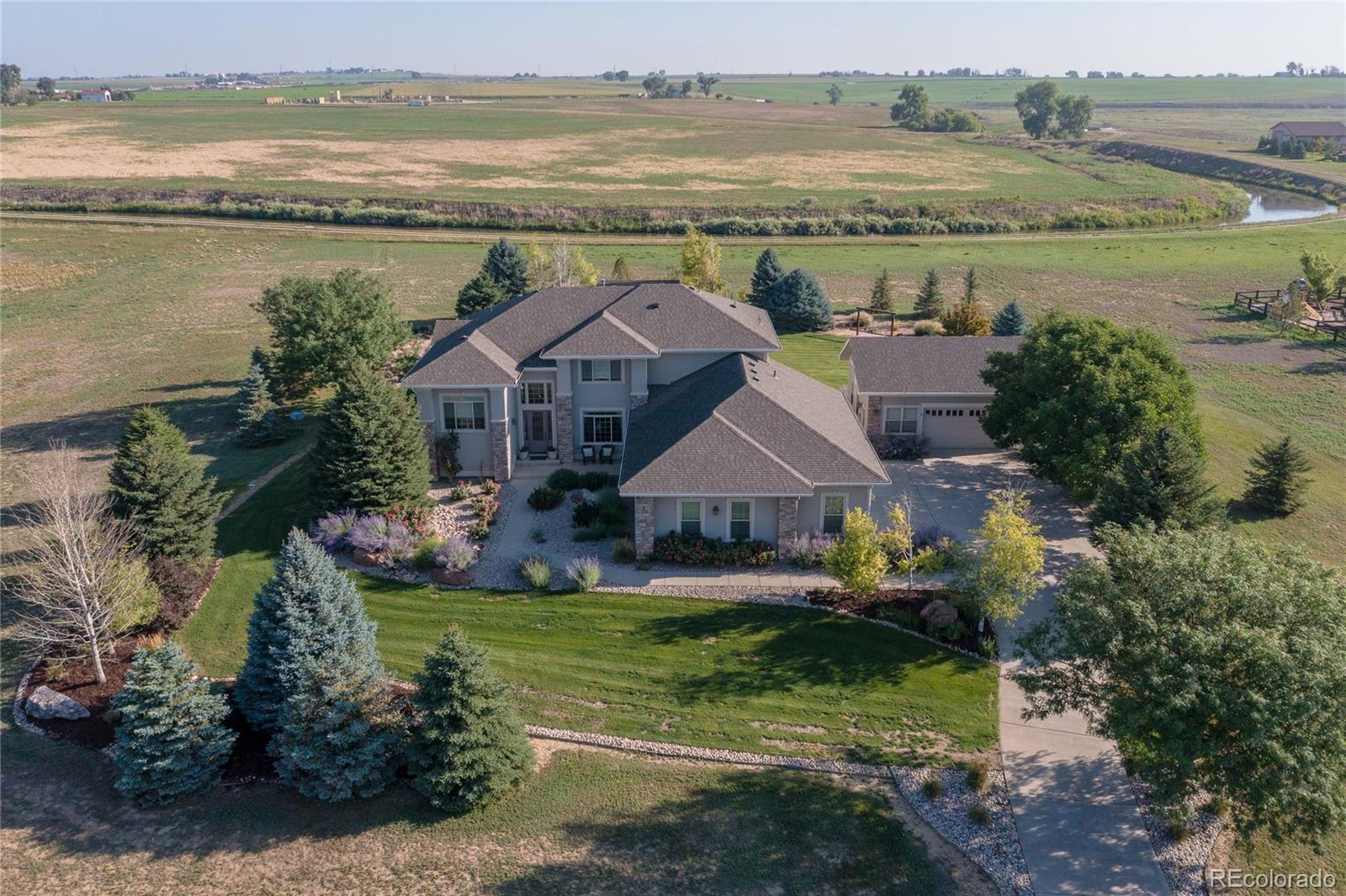 an aerial view of a house with big yard and large tree