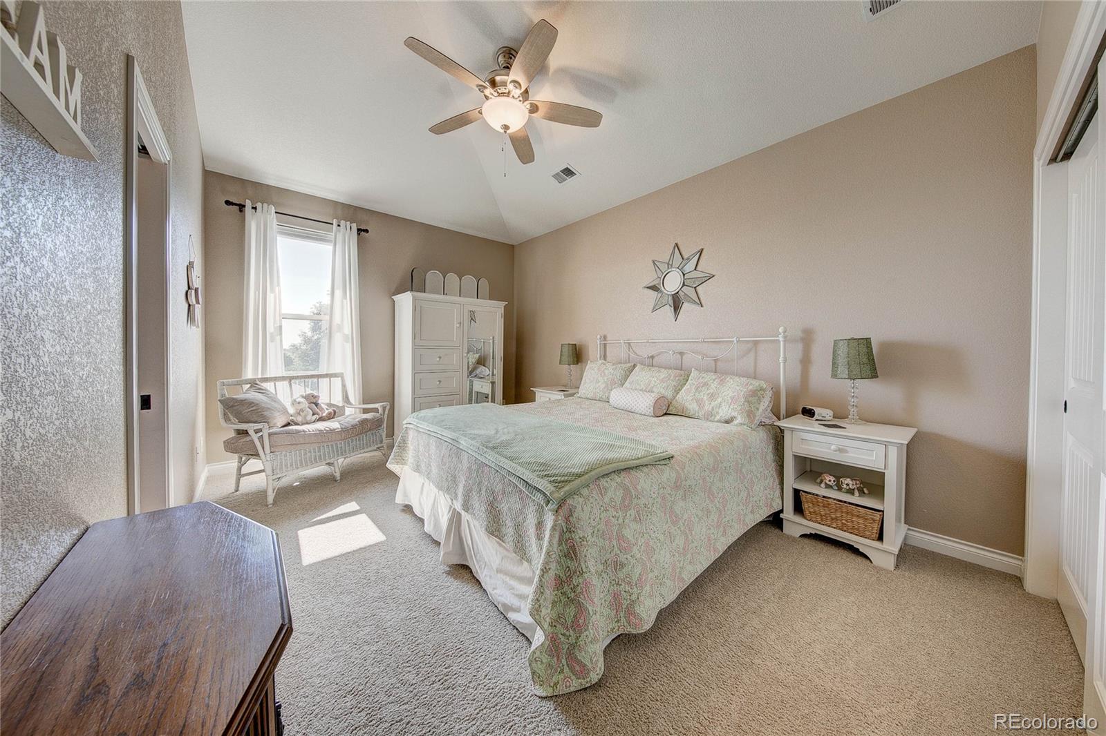 37053 Soaring Eagle Circle Severance, CO 80550 - Photo 27 of 35 a spacious bedroom with a bed and a chandelier