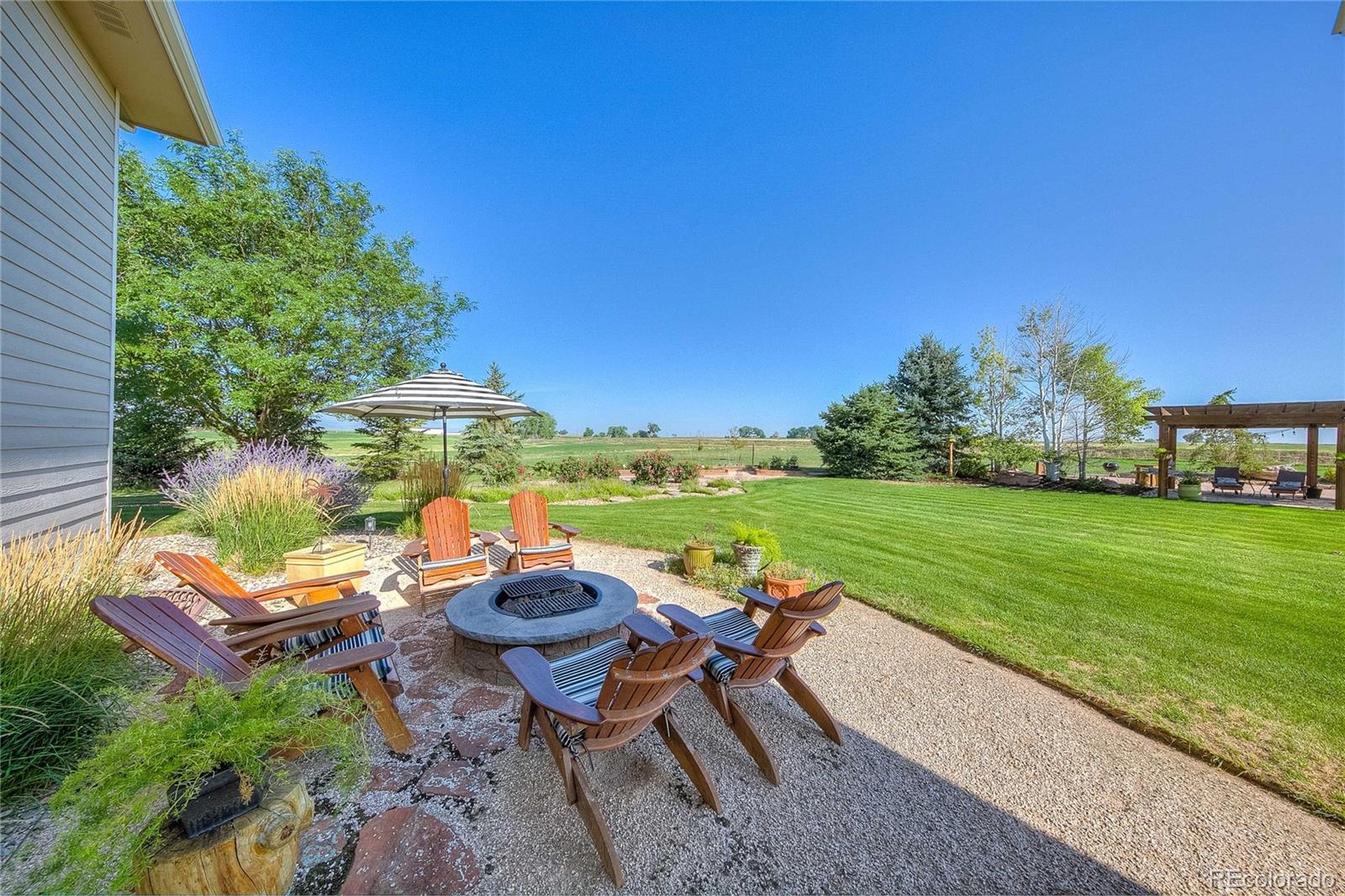 37053 Soaring Eagle Circle Severance, CO 80550 - Photo 7 of 35 a view of a lake with lawn chairs and a fire pit