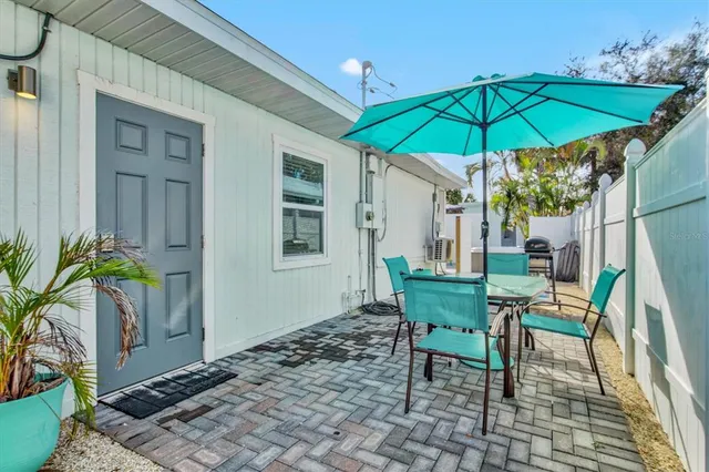 a backyard of a house with table and chairs