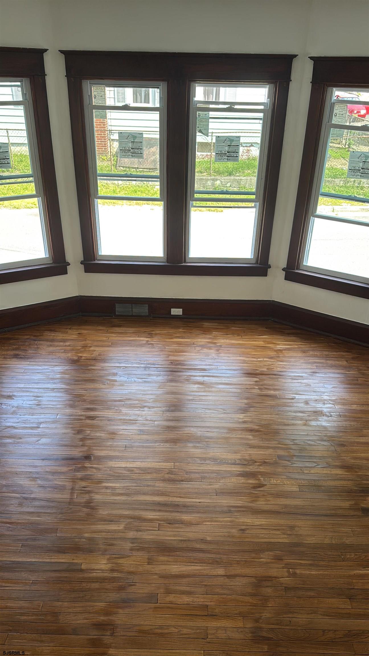 87 West Pitman Street Penns Grove, NJ 08069 - Photo 4 of 9 an empty room with wooden floor and windows