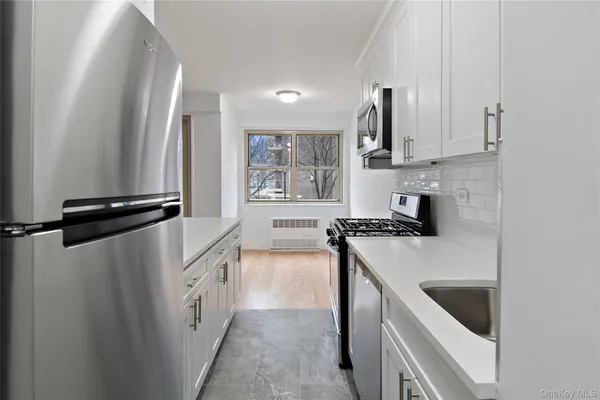 a kitchen with white cabinets and white appliances