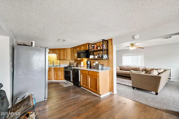 a kitchen with kitchen island wooden floors appliances and cabinets