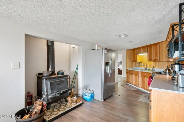 a living room with furniture a flat screen tv and a refrigerator