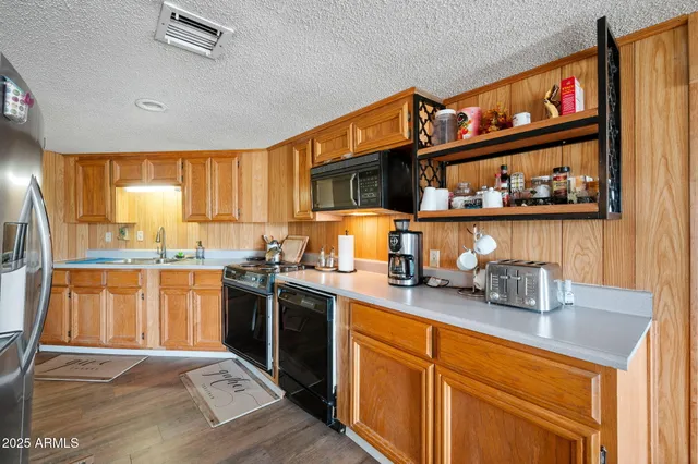 a kitchen with stainless steel appliances granite countertop a sink stove and cabinets