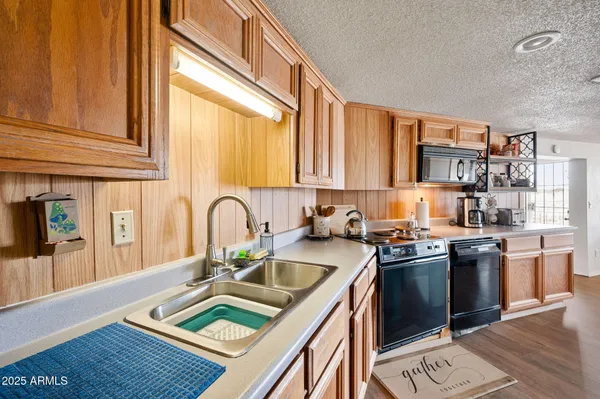 a kitchen with stainless steel appliances granite countertop a stove a sink dishwasher and cabinets with wooden floor