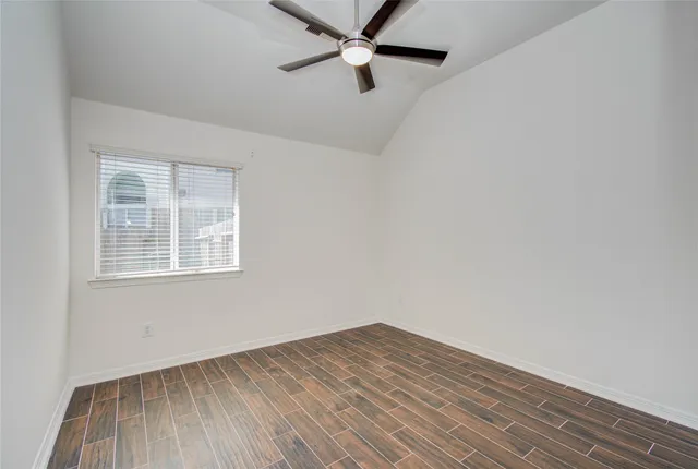 an empty room with a window and a ceiling fan