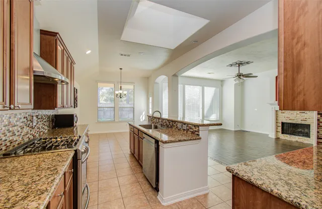 a kitchen with stainless steel appliances granite countertop a stove oven and a refrigerator