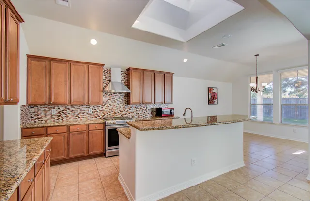 a kitchen with stainless steel appliances granite countertop a sink and a stove top oven