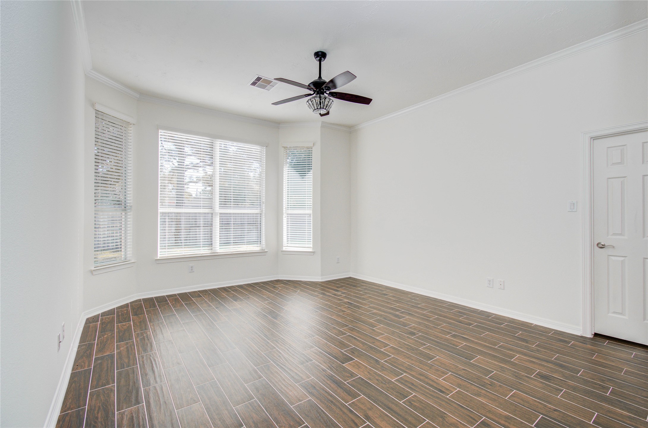 10714 Barker Lake Cypress, TX 77433 - Photo 33 of 43 an empty room with wooden floor a ceiling fan and windows