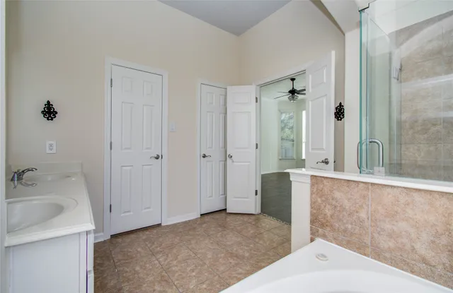 a bathroom with a tub sink and glass door