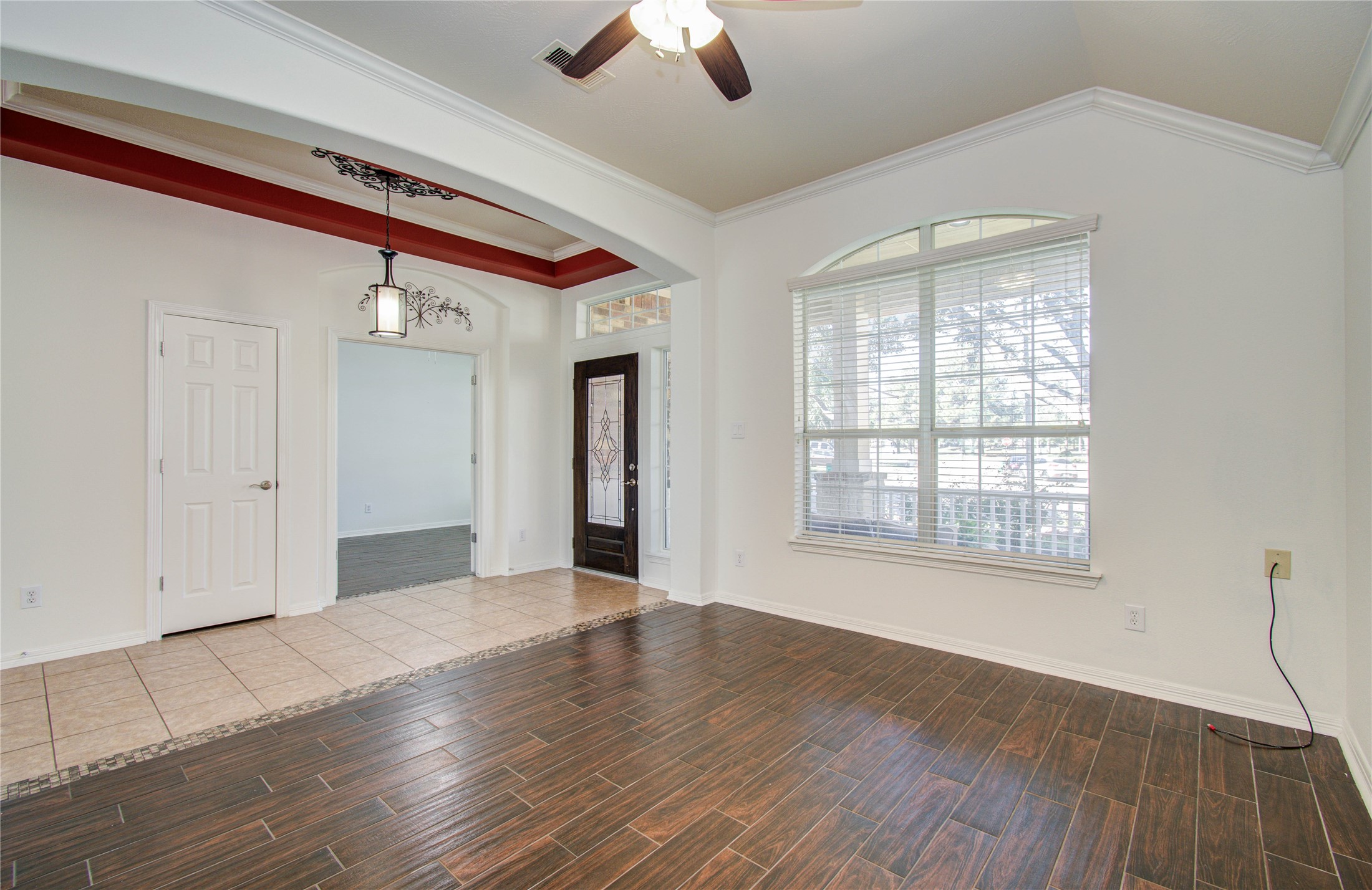 10714 Barker Lake Cypress, TX 77433 - Photo 4 of 43 an empty room with wooden floor chandelier fan and windows
