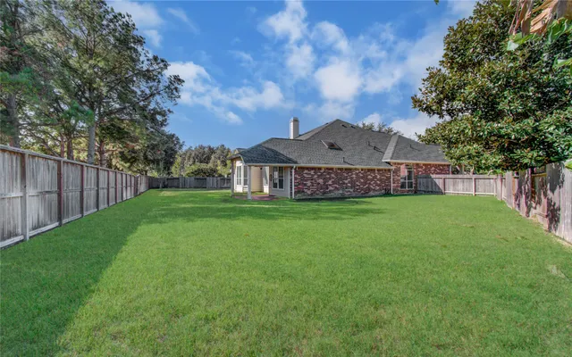 a view of a big house with a big yard and large tree