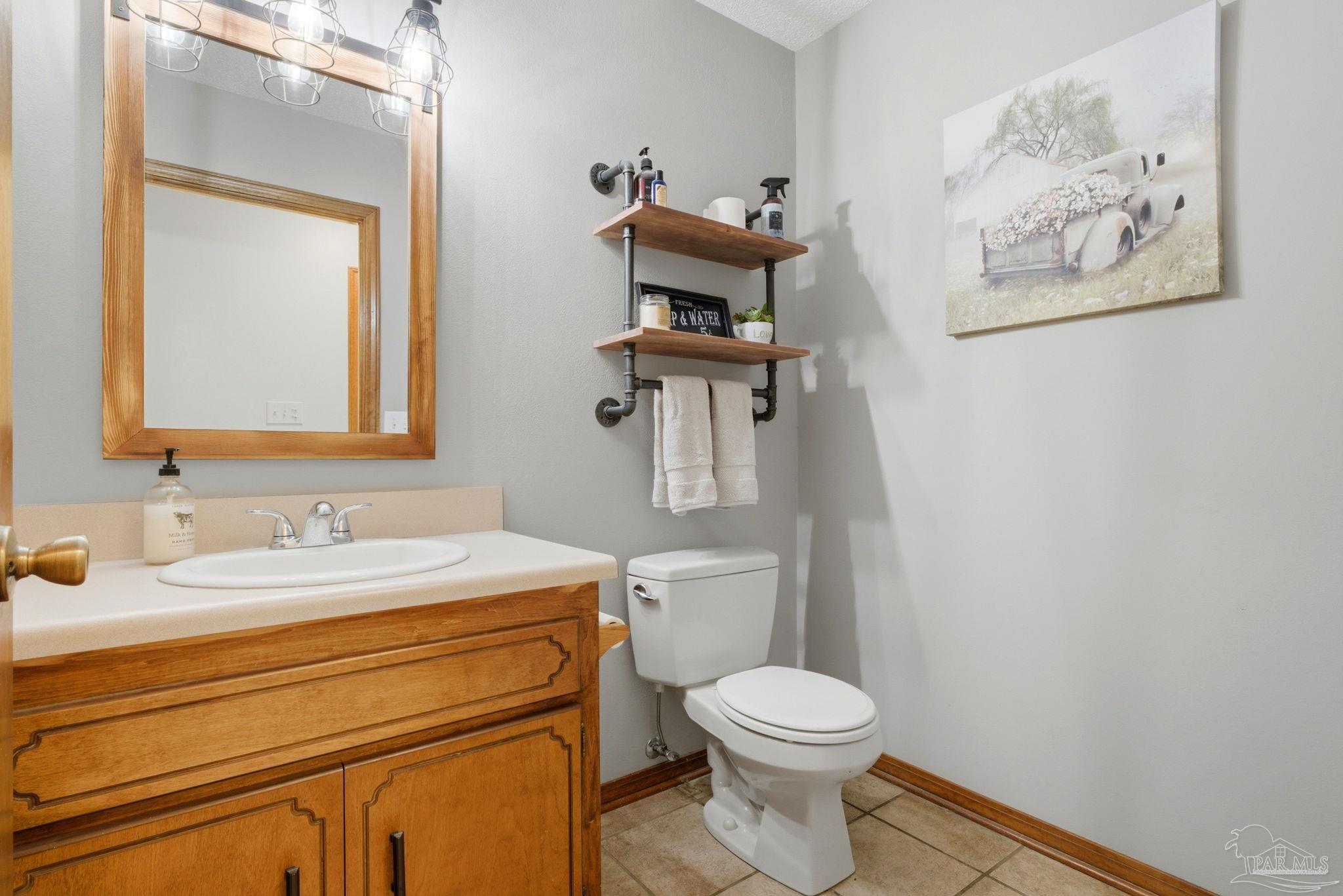6870 Martin Road Milton, FL 32570 - Photo 35 of 48 a bathroom with a toilet sink and mirror