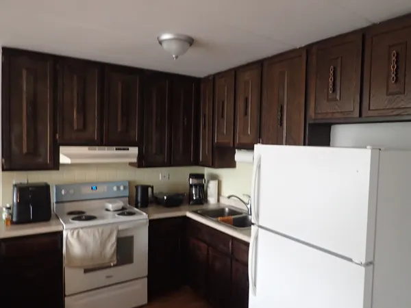 a kitchen with a refrigerator a stove a sink and cabinets