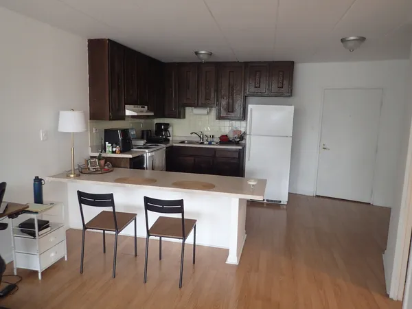a kitchen with a table chairs refrigerator and cabinets