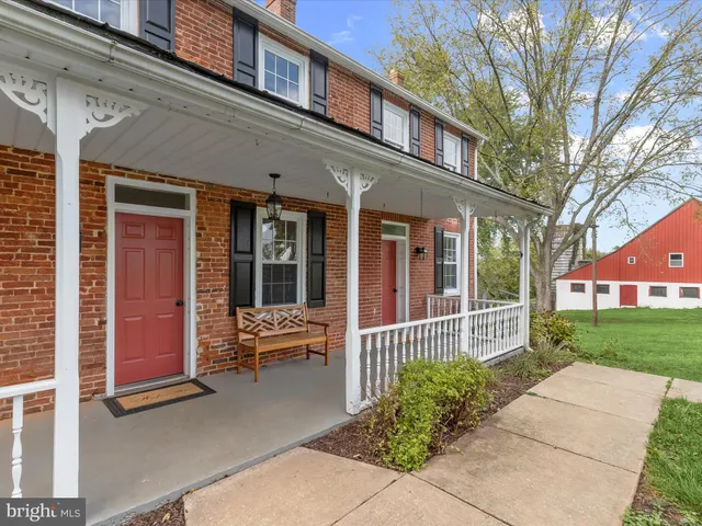 front view of a brick house with a large window and table and chairs