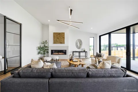 a living room with fireplace furniture and a large window