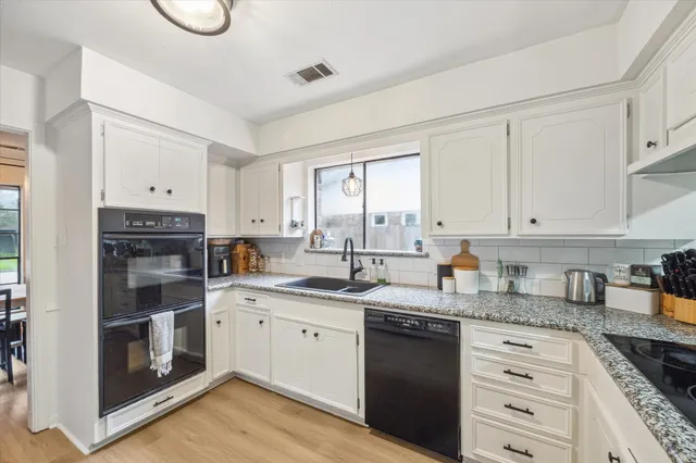 a kitchen with granite countertop white cabinets and white appliances
