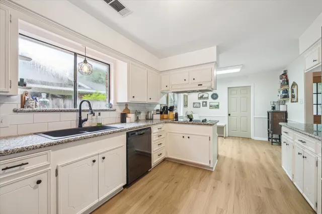 a kitchen with a sink wooden floor and windows