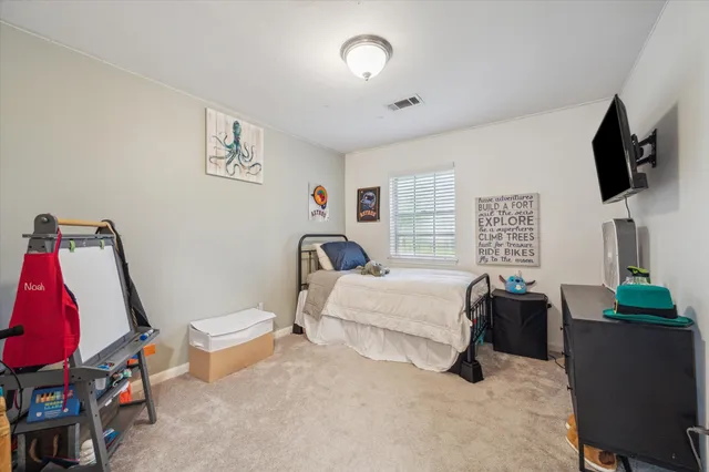 a bedroom with furniture and a flat screen tv