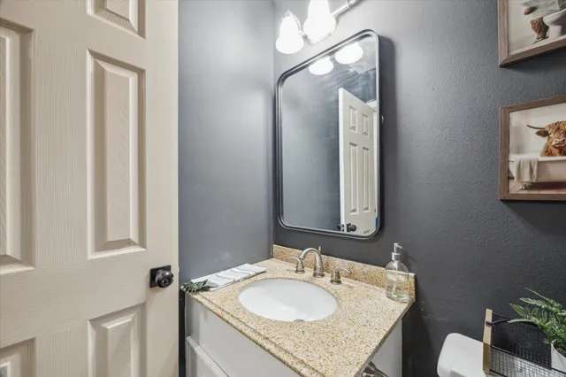 a bathroom with a granite countertop sink and a mirror