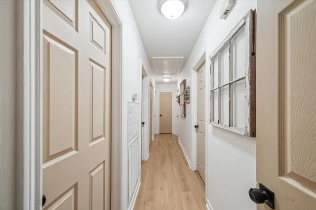 a view of a hallway with wooden floor and staircase