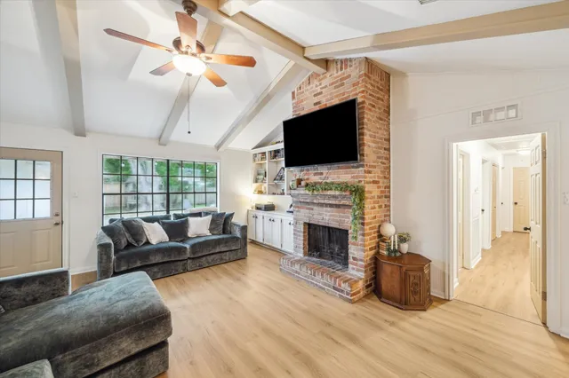 a living room with furniture a fireplace and a flat screen tv