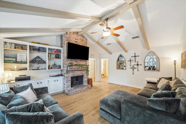 a living room with furniture a fireplace and a flat screen tv