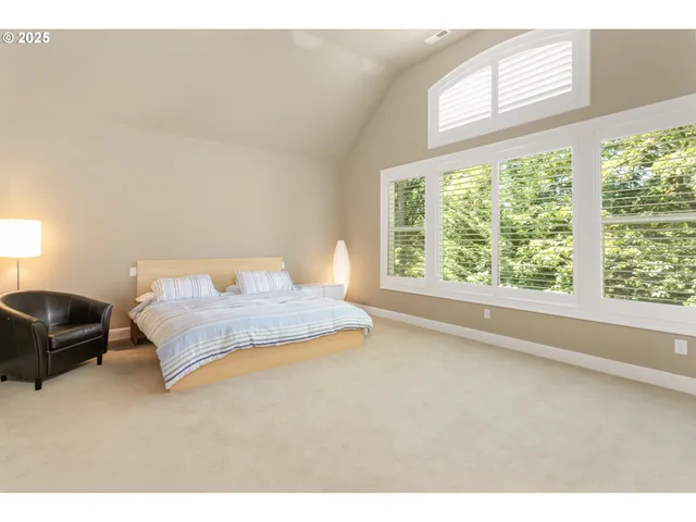 a bedroom with a large bed and a large window