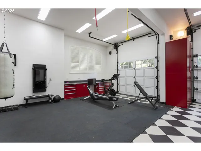 a living room with furniture a flat screen tv and gym equipment