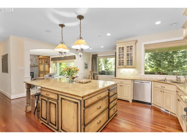 a kitchen that has a lot of white cabinets and wooden floor