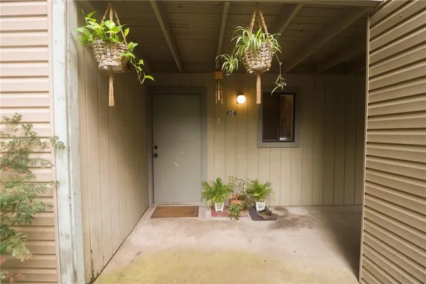 a view of a hallway with chandelier and a potted plant