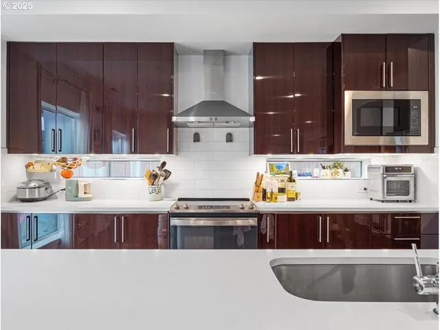 a view of kitchen island a sink wooden floor and living room