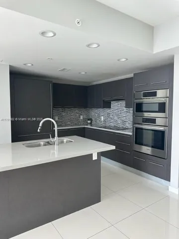 a kitchen with stainless steel appliances a sink stove and cabinets