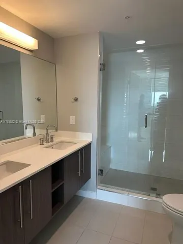 a bathroom with a double vanity sink toilet and shower