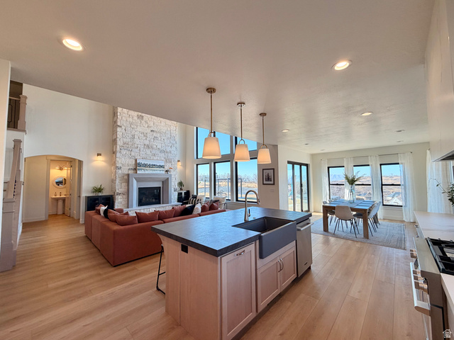 3626 Riverstone Road Mapleton, UT 84664 - Photo 57 of 58 Kitchen with open floor plan, a kitchen island with a Farm sink, Signature Kitchen Suite Appliances, a fireplace, and dark countertops