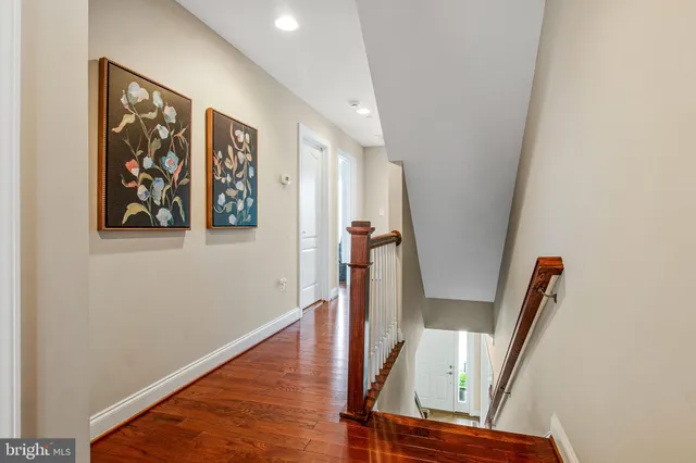 a view of a hallway with wooden floor and stairs
