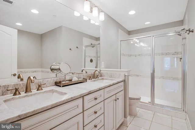 a bathroom with a double vanity sink mirror and toilet