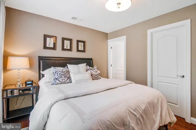 a large bed sitting in a bedroom next to a window
