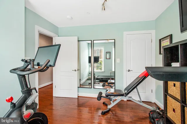 a room with gym equipment and wooden floor