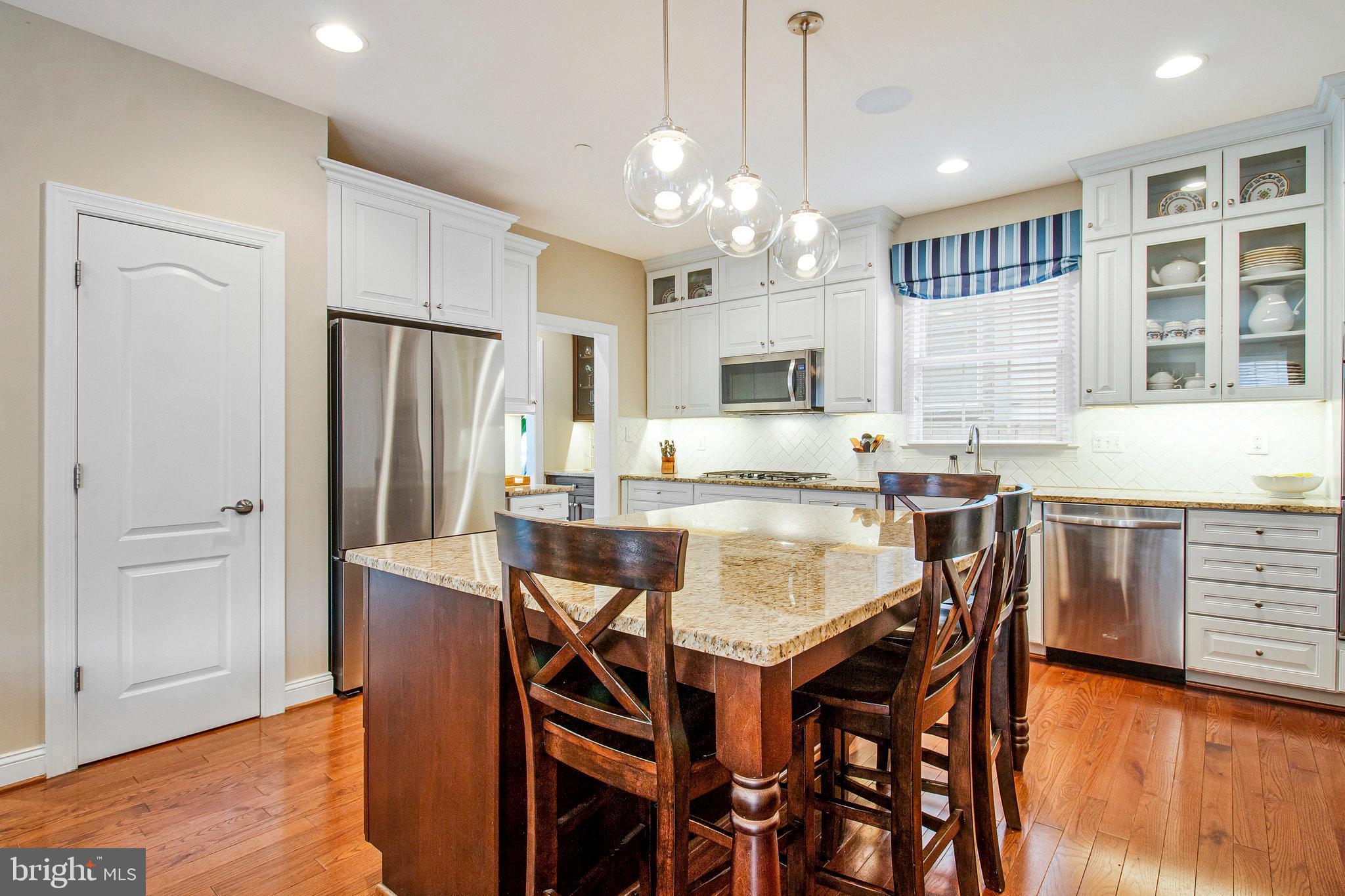208 Beacon Place Northeast Washington, DC 20011 - Photo 4 of 48 a kitchen with stainless steel appliances granite countertop a dining table chairs refrigerator and microwave