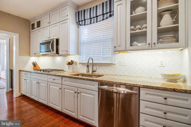 a kitchen with granite countertop stainless steel appliances a sink and cabinets