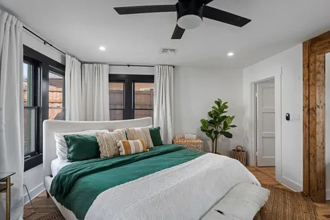 a bedroom with a large bed and a potted plant