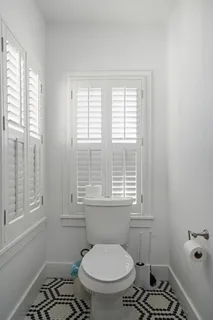 a bathroom with a toilet a window and a shower