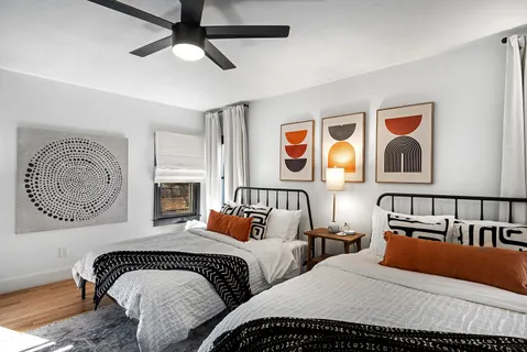 a bedroom with two beds and painting on the wall