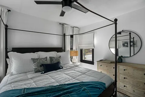a bedroom with a large bed and a mirror